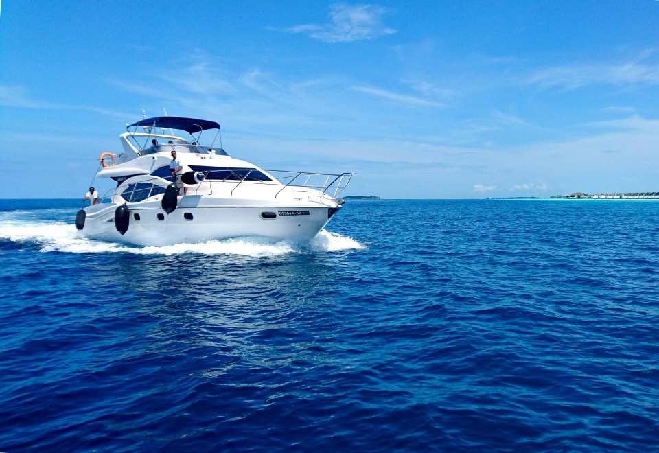 Yate blanco y azul en el mar bajo un cielo azul durante el día